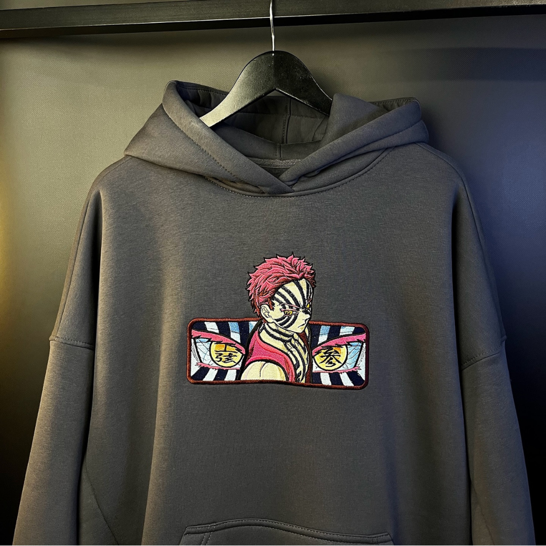 Akaza embroidery design stitched on the chest of a grey hoodie